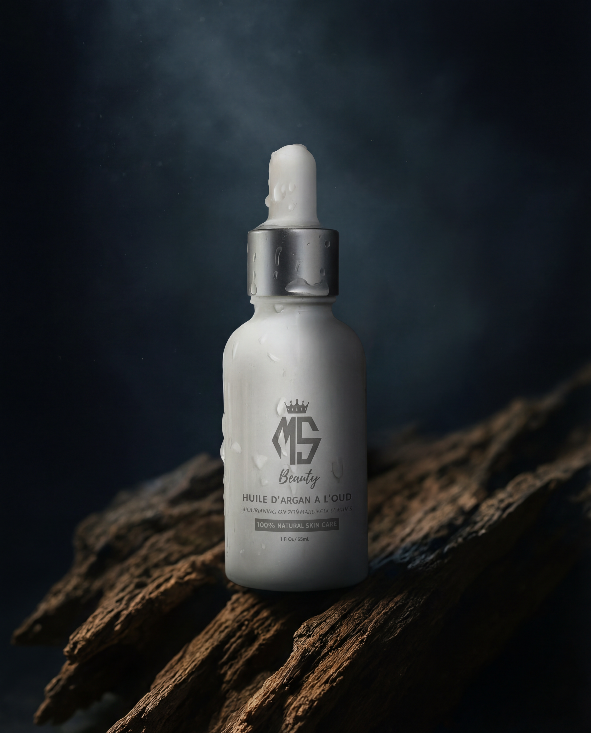 Amber glass bottle of argan oil with oud on dark textured wood background